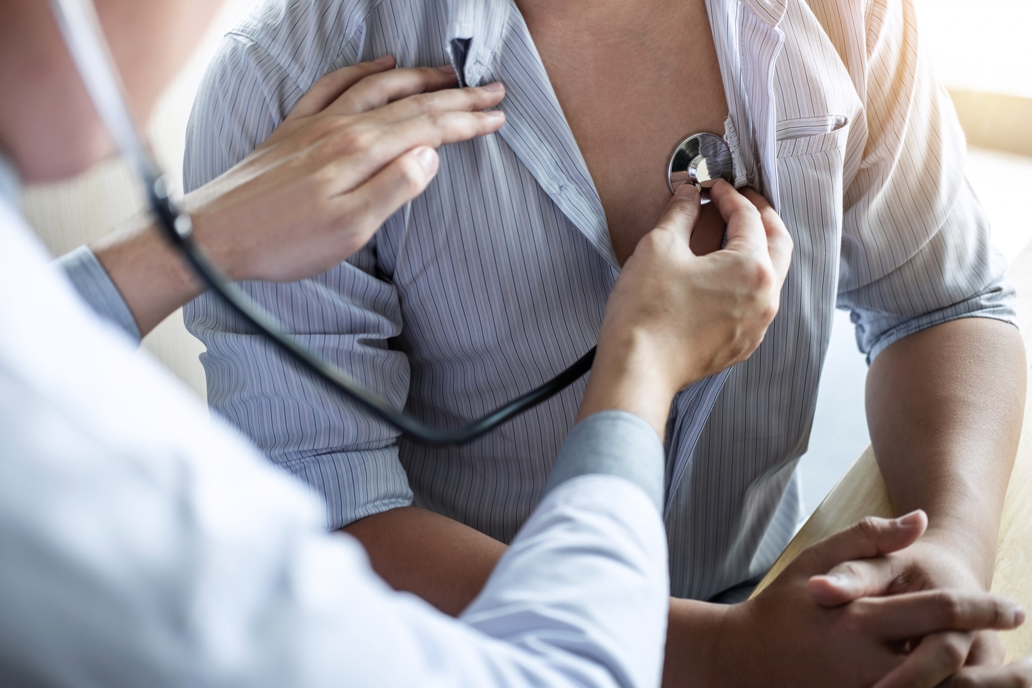 Healthcare professional listening to a patient's heartbeat