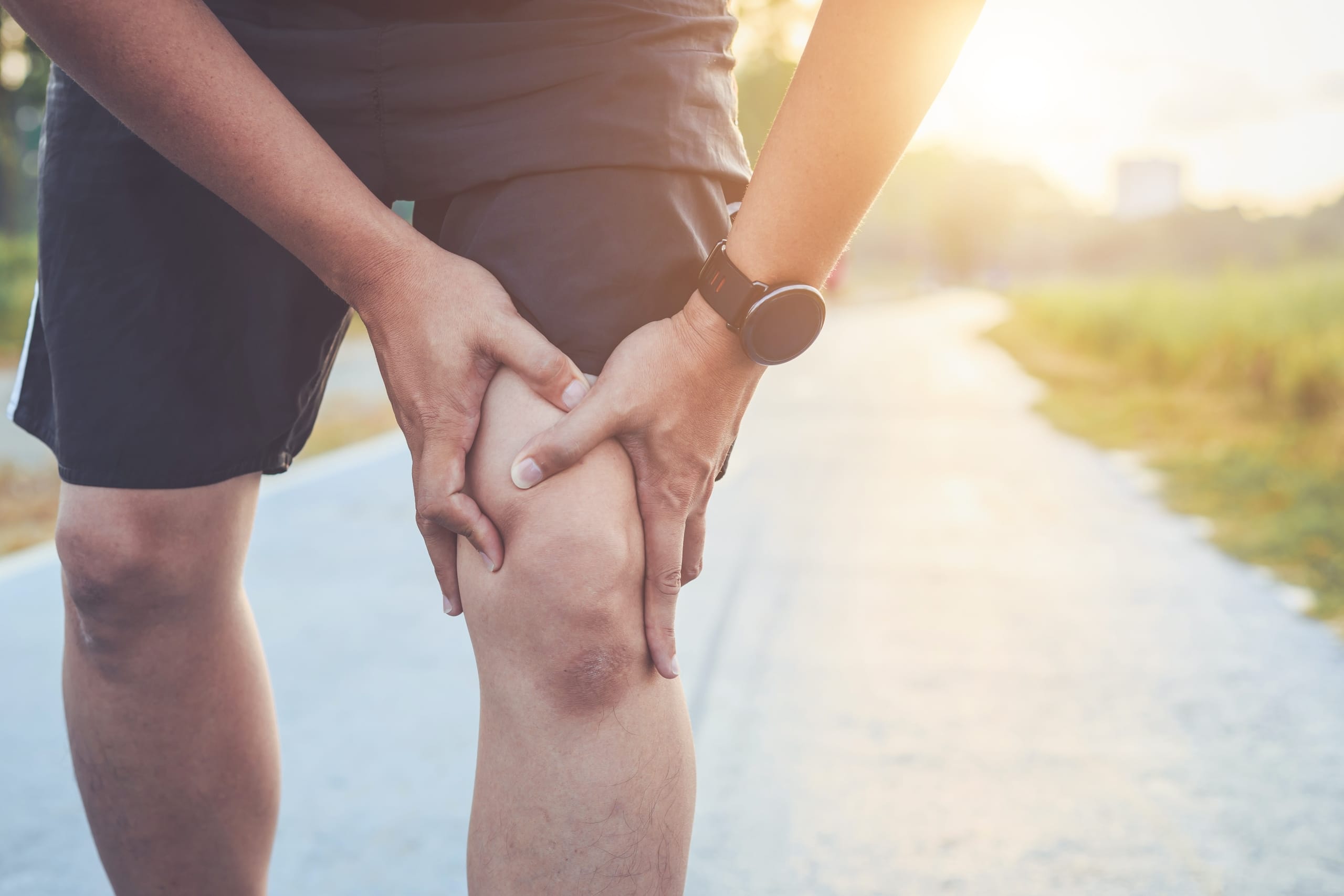 Injured man holding his knee