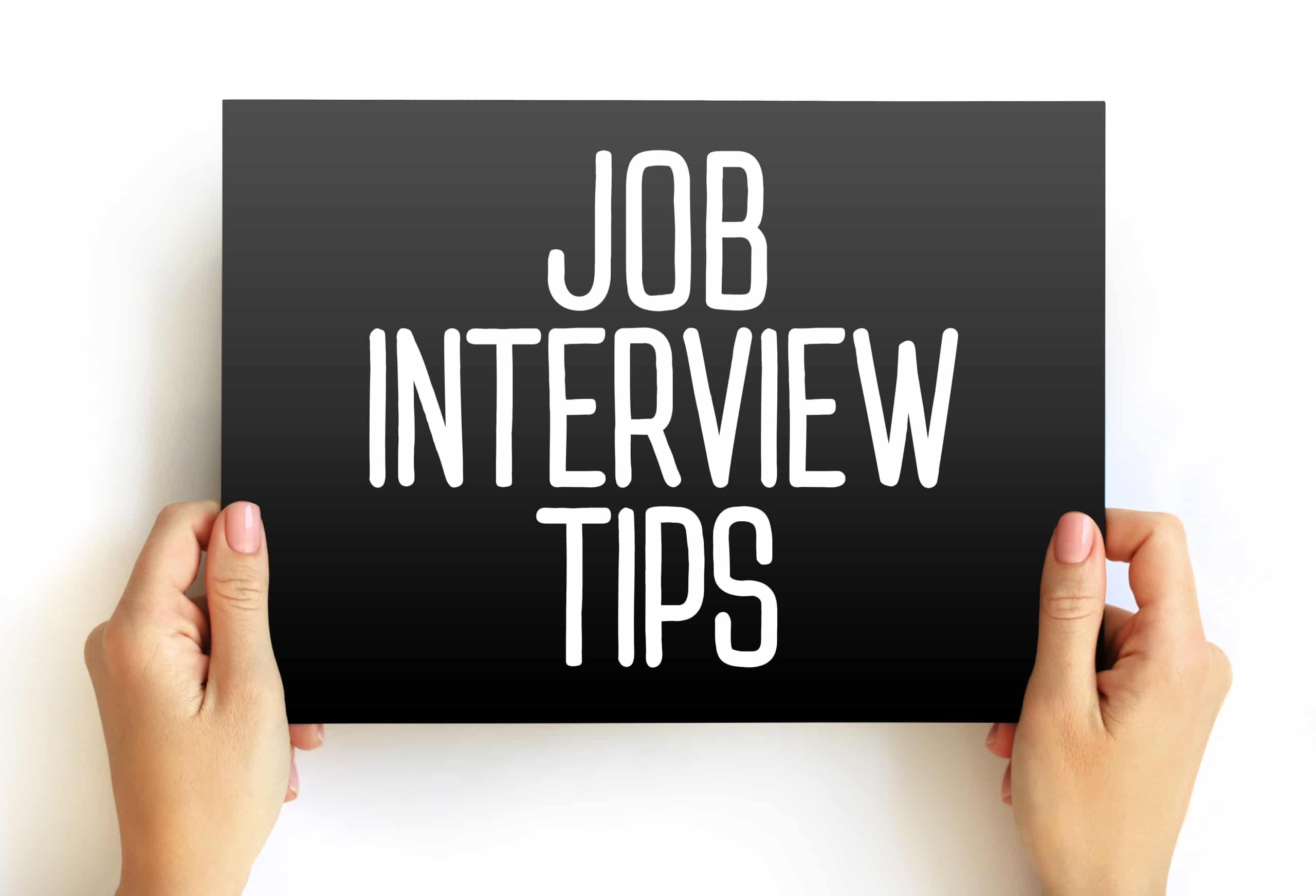 Hands holding a board that says job interview tips
