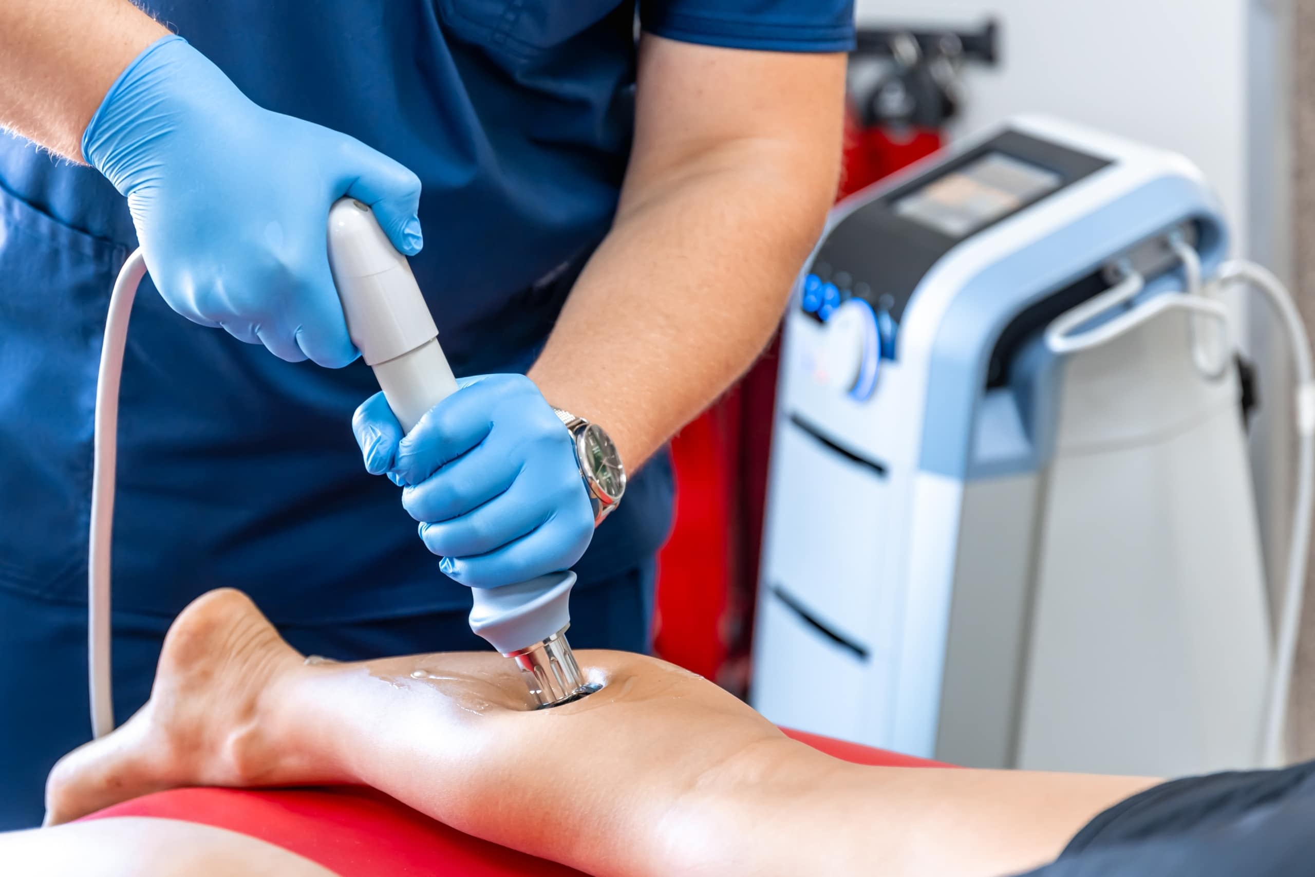 Medical professional performing ultrasound therapy on a patient's shin