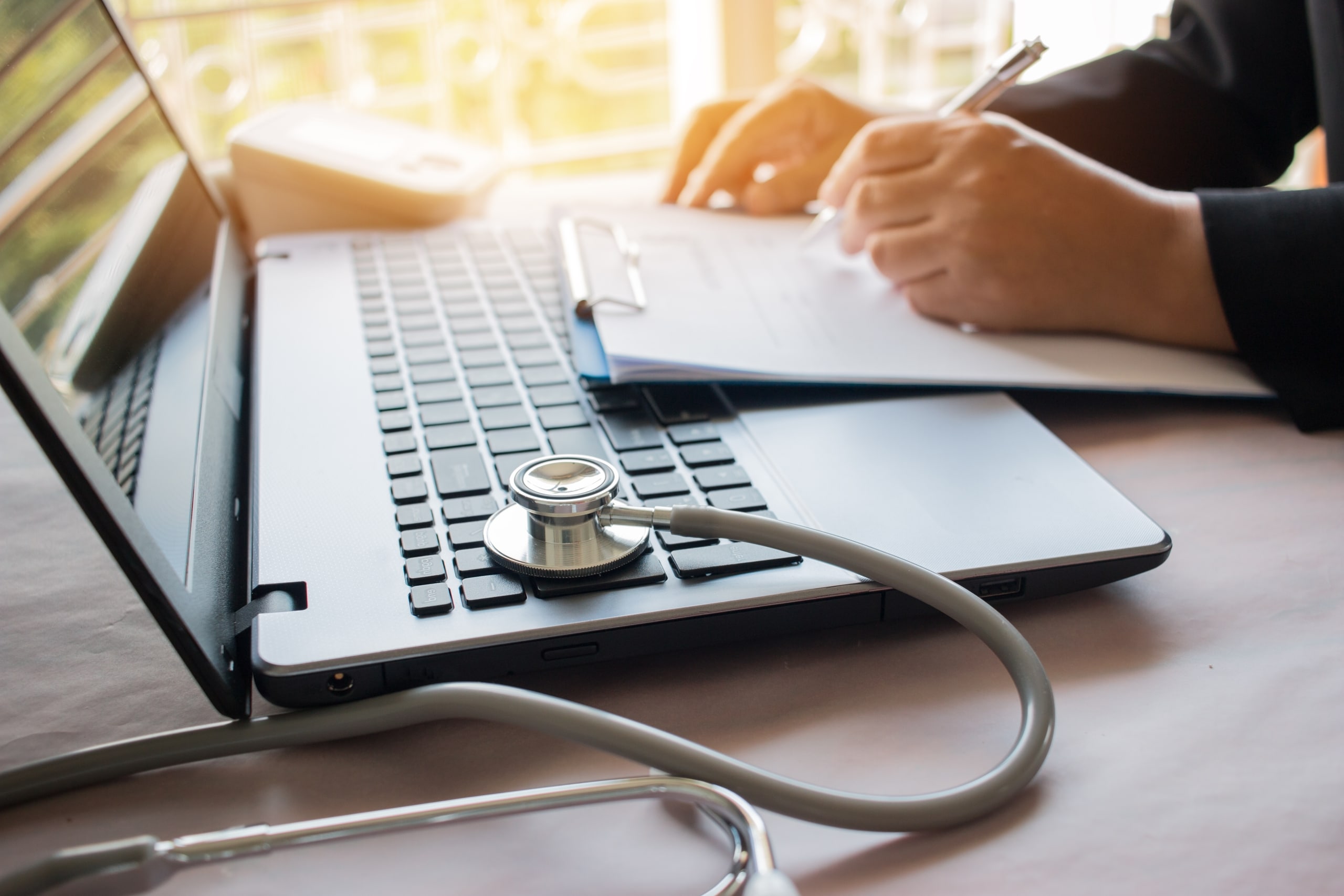 Medical student using a laptop with a stethoscope on the side